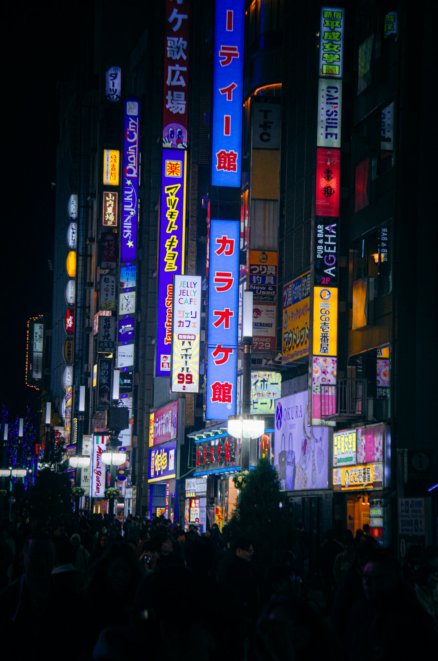Rua noturna em Tóquio coberta de placas e letreiros neon japoneses sobrepostos em densidade caótica