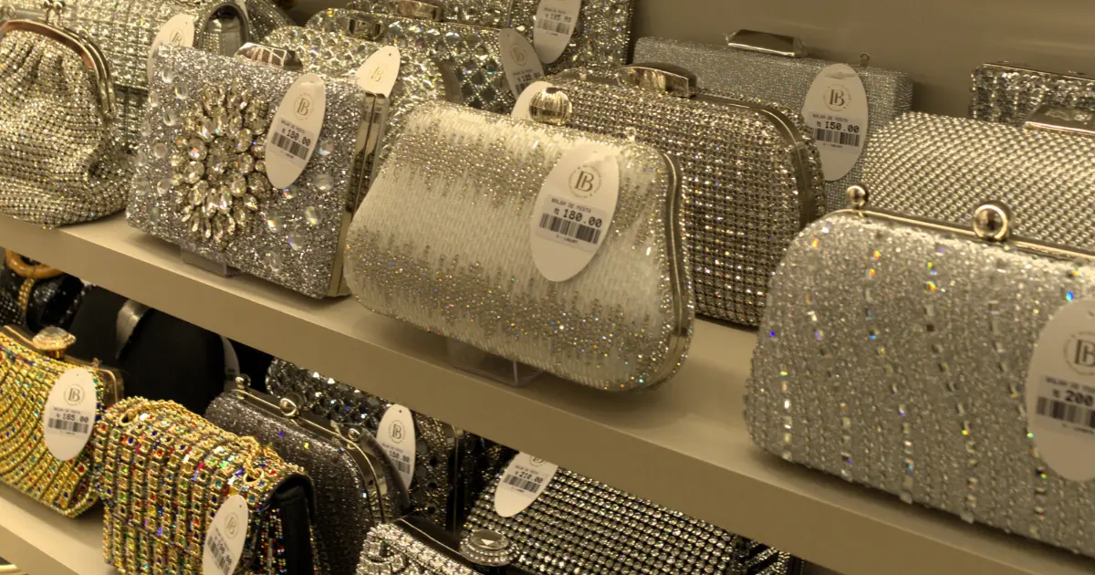 Prateleira com modelos de bolsas de festa brilhantes da franquia Donna Bendita